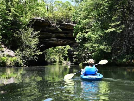 Kayaking beneath a natural sandstone bridge at Pickett State Park